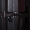 Close up of internal securing strap inside double extinguisher cabinet showing black buckle and textured surface