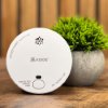 kidde 2030 dsr optical smoke alarm shown in front of a small green plant on a wooden surface