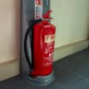 ultrafire economy fire extinguisher stand single grey holding a red fire extinguisher against a wall on a carpeted floor