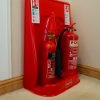 ultrafire economy fire extinguisher stand double red holding two red fire extinguishers placed on a carpeted floor next to a wall