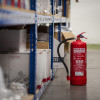 ultrafire 6ltr water mist extinguisher standing on the floor in a warehouse aisle next to shelving with boxes