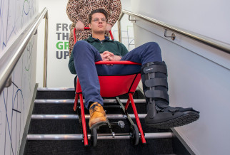 Person sitting in an Ultrafire Descender Evacuation Chair being guided down a staircase