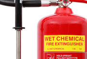 A red wet chemical fire extinguisher with a yellow label